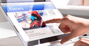 A person scrolls through news on a tablet